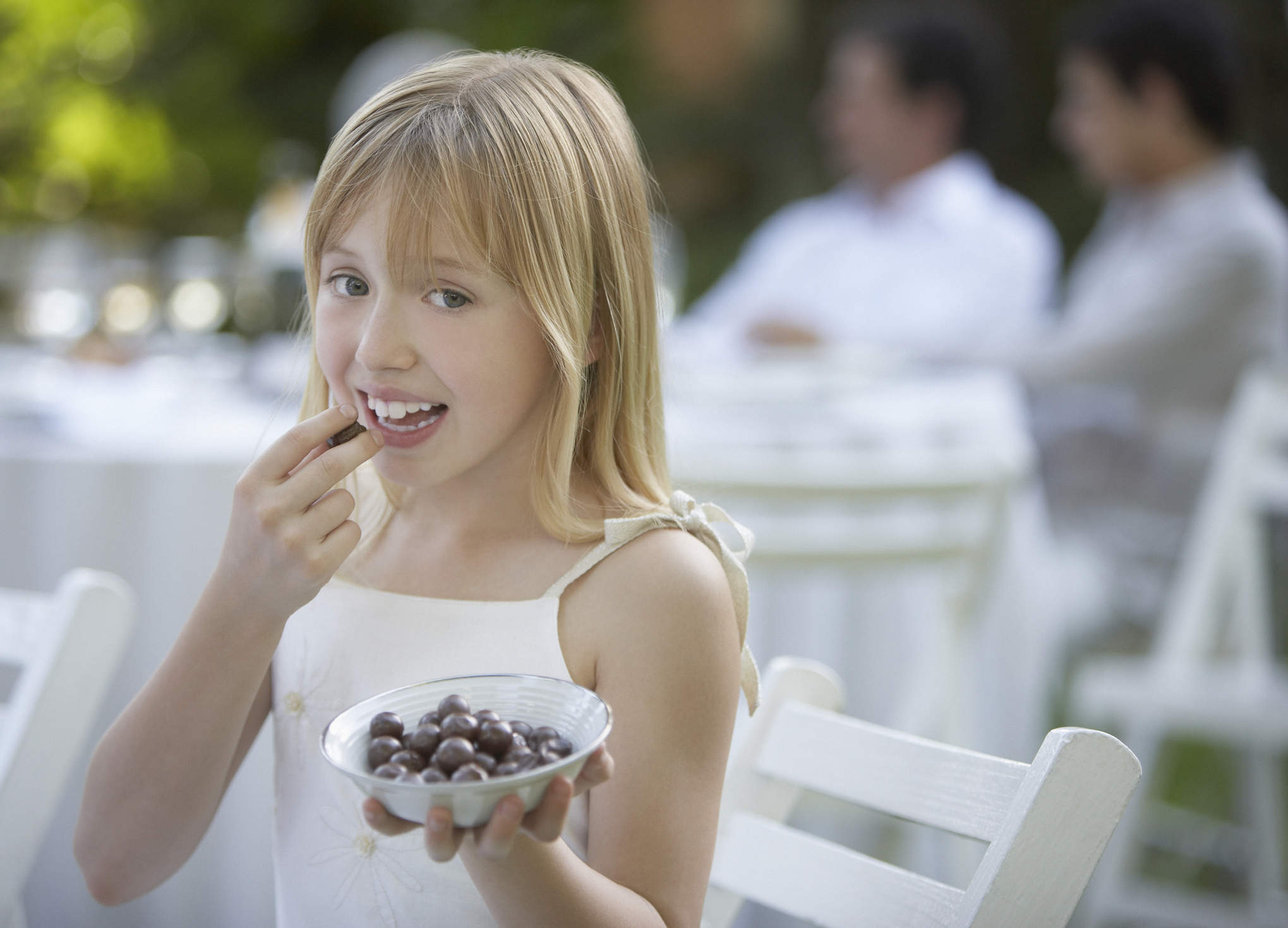 Young girl at outdoor party eating olives